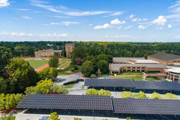 Aerial view of solar carport canopies at Davidson College with the campus and athletic fields beyond