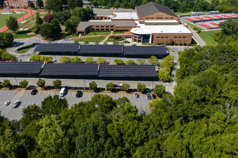 Long solar carport canopy run with Davidson College buildings in the background