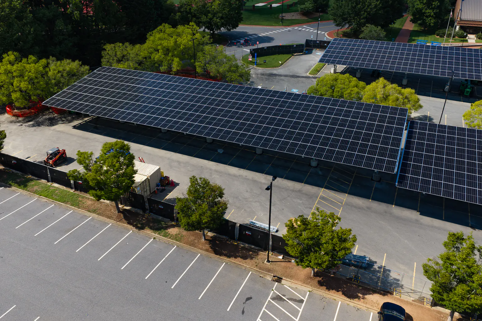 Low aerial close-up of a solar carport canopy showing the module layout