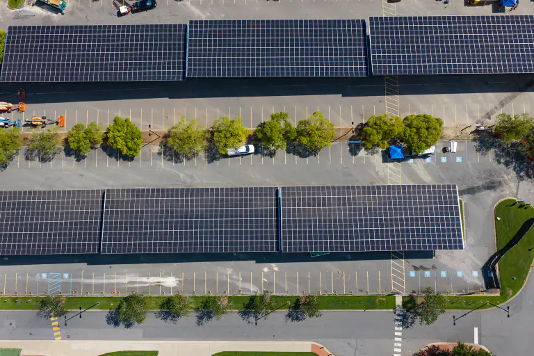 Near top-down aerial of two solar carport canopy rows