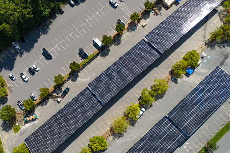 Overhead aerial of diagonal solar canopy rows over parking bays