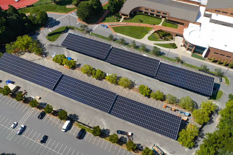 Solar canopies with Davidson College campus buildings in the frame