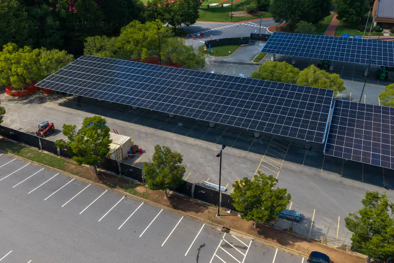 End-on aerial view of a solar carport canopy over an empty parking lot