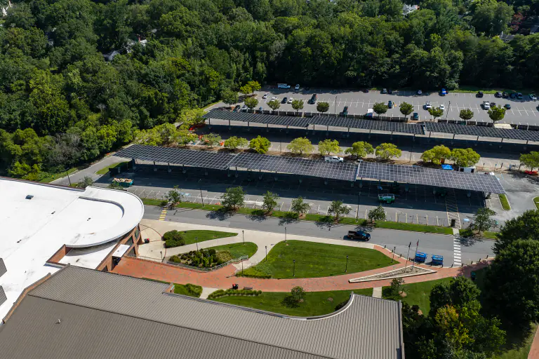 Aerial of solar canopies with a curved brick campus building