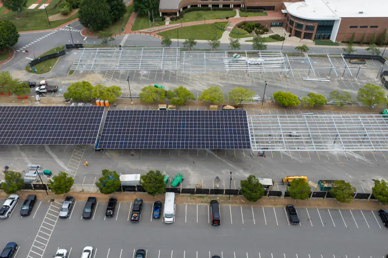 Aerial of solar panels partially installed on carport canopy framework
