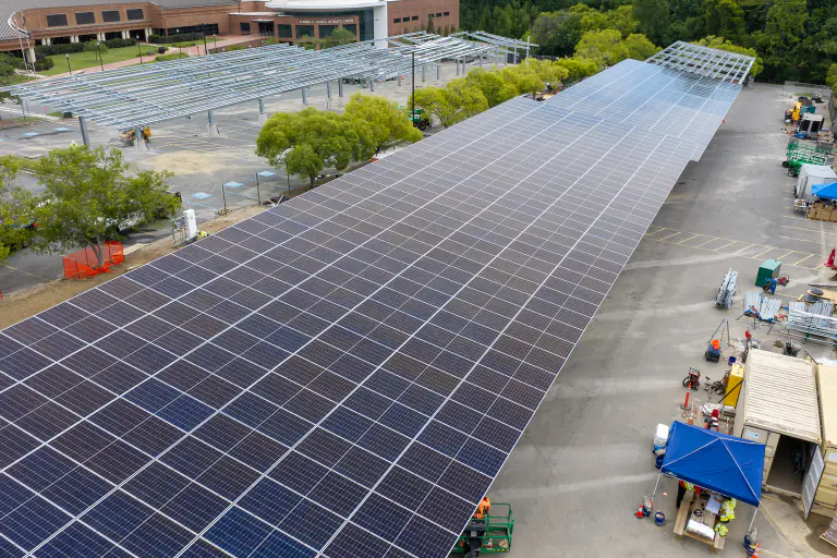 Close aerial of a completed solar canopy surface with unfinished framework beyond
